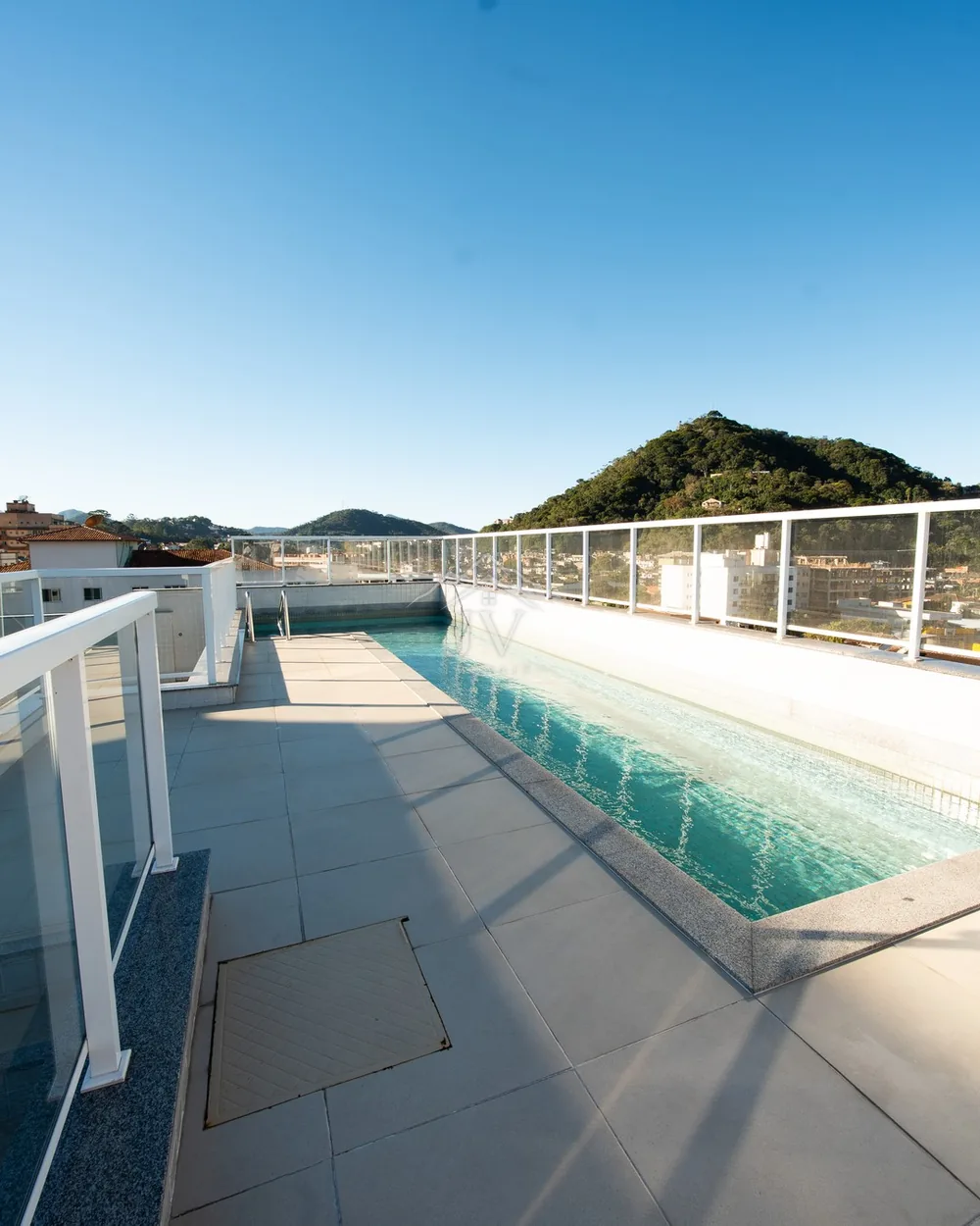Piscina na cobertura do prédio, com a serra ao fundo